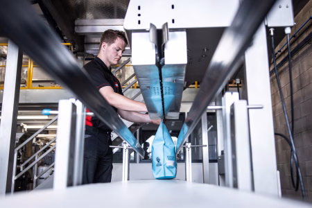 man using a heavy duty vertical band sealer machine for a production line